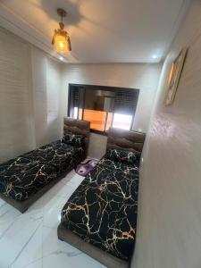 a bedroom with two beds in a room at relaxtime avec ascenceur in El Jadida