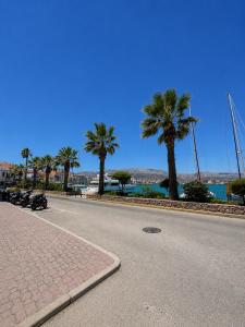 a street with palm trees on the side of a road at Almeta Apartments Port in Chios