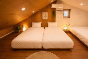 two beds in a room with wood paneling at On Stay - Hotel Quality Stay in Seoul