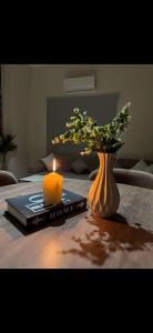 a candle sitting on a table with a vase with flowers at Garden C Hotel Nile Plaza in Cairo +4 photos