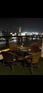 a table and chairs sitting on a balcony at night at Garden C Hotel Nile Plaza in Cairo