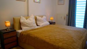 a bedroom with a bed with white pillows and two lamps at Apartment 24 modern & gemütlich in Dessau