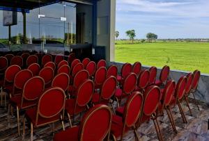 a row of red chairs in a room with a field at Town Tulip in Karativu