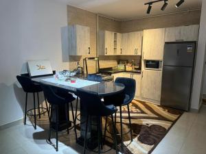 a kitchen with a table with chairs and a refrigerator at Chalet in Blumar Ain soknha in Ain Sokhna