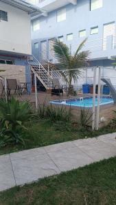 a swimming pool in front of a building with a palm tree at Studio Home 4 in Jacareí