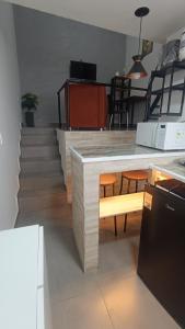 a kitchen with a counter with a table and chairs at Studio Home 4 in Jacareí