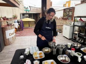 a woman in an apron preparing food on a table at Casa Huaca in Lima