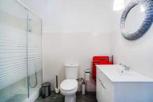 a bathroom with a toilet and a sink and a mirror at Casa da Avenida in Cascais