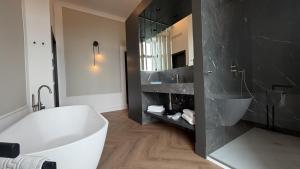 a bathroom with a white tub and a black wall at Palazzo Montella in Naples