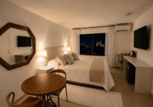 a bedroom with a bed and a mirror and a table at Hotel Carande, Papudo in Papudo