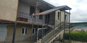 a house with a staircase on the side of it at Дом мичти in Tsalka
