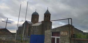 an old church with two towers on top of it at Дом мичти in Tsalka