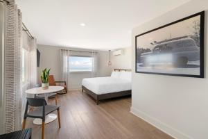 a hotel room with a bed and a picture of a car at Ocean Surf at York Beach in York