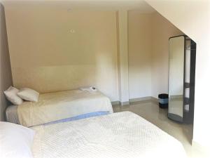 a room with two beds and a mirror at FerG in Lligua