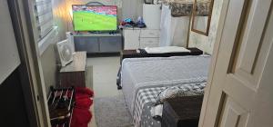 a small room with two beds and a television at Victoria complex in Willemstad +5 photos