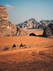 two people riding horses in the desert at camp sand in Disah