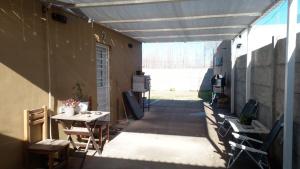 an outdoor patio with a table and a tv at Marce's house in General Roca