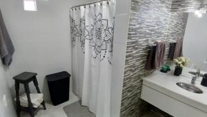 a bathroom with a shower curtain and a sink at Marce's house in General Roca +15 photos
