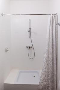 a white bathroom with a shower curtain and a sink at Atriumhof in Rust