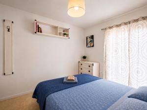 a bedroom with a blue bed and a window at Daisy House Golden Beach Area in Potamiá