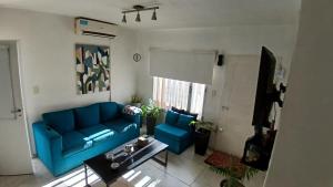 a living room with a blue couch and a table at Marce's house in General Roca