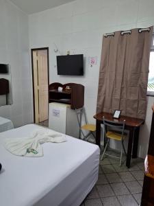 ein Zimmer mit einem Bett, einem Schreibtisch und einem Tisch in der Unterkunft Hotel Ilha dos Azulejos in São Luís