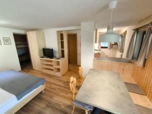 a room with a table and a bed and a kitchen at Apartmaji Zupančič in Bohinj