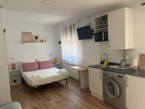 a small kitchen with a couch and a washing machine at Casa Adrianykenia in San Martín de Laspra