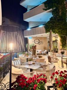 a patio with tables and chairs and flowers at OLEO hotel in Momchilgrad
