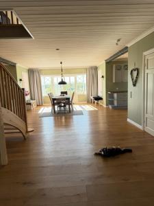 a living room with a table and a wooden floor at Naturskönt boende nära sjö in Ör +6 photos