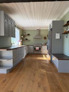 a large kitchen with wooden floors and stainless steel appliances at Naturskönt boende nära sjö in Ör