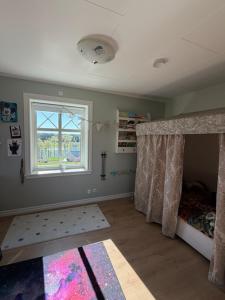 a childs bedroom with a bed and a window at Naturskönt boende nära sjö in Ör