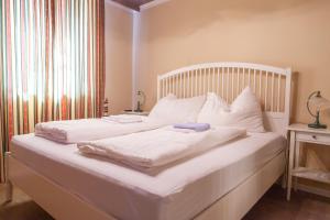 a large white bed with white sheets and pillows at Atriumhof in Rust