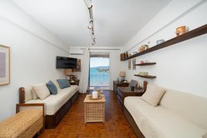 a living room with two couches and a television at KYMA by A&D Properties in Porto Rafti