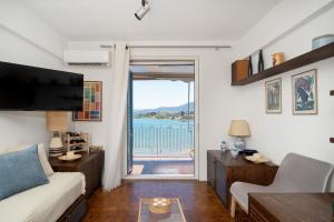 a living room with a view of the water at KYMA by A&D Properties in Porto Rafti