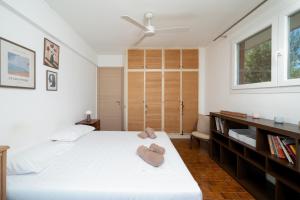 a bedroom with a large white bed with two hearts on it at KYMA by A&D Properties in Porto Rafti