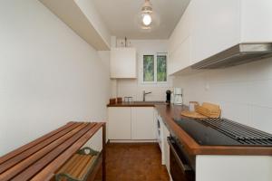 a kitchen with white cabinets and a bench in it at KYMA by A&D Properties in Porto Rafti