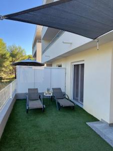 a patio with two chairs and a table and an umbrella at Number One Apartments in Vir