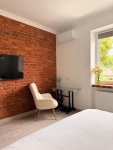 a bedroom with a brick wall and a chair and a table at Федорцьо in Mukacheve