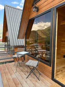 a patio with a table and chairs on a building at Mountain Stories Kazbegi-Stepantsminda in Kazbegi