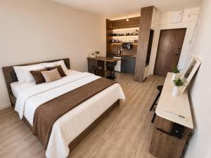 a bedroom with a bed and a desk and a kitchen at Alula Apartments 2 in Bar