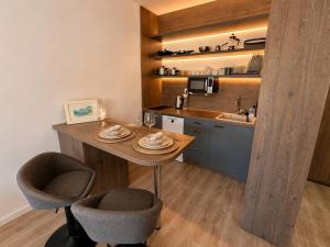 a kitchen with a table and two chairs and a sink at Alula Apartments 2 in Bar +8 photos
