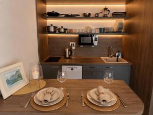 a kitchen with a table with plates and wine glasses at Alula Apartments 2 in Bar