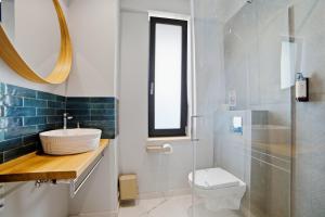 a bathroom with a sink and a toilet and a mirror at Senses Villa By PopDan in Vama Veche