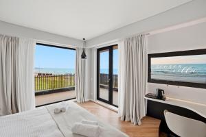 a bedroom with a bed and a view of the ocean at Senses Villa By PopDan in Vama Veche