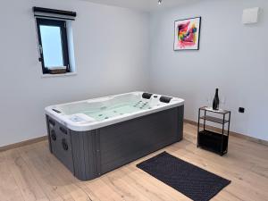 a jacuzzi tub in a white room with a window at House Avena with spa & gym in Labin +17 photos