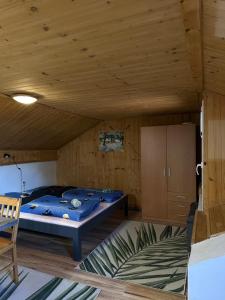 a bed in a room with a wooden ceiling at Apartmán Gál 3 in Kvačany
