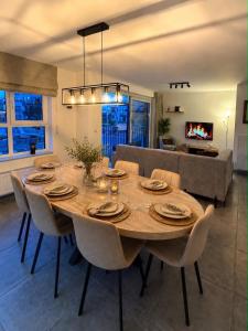 a dining room with a large wooden table and chairs at L'Appart de Grand-Père in Oudenburg