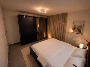 a bedroom with a large white bed and a window at L'Appart de Grand-Père in Oudenburg