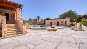 a stone patio with a fountain and a building at Residence Il Corallo - Guitgia in Lampedusa